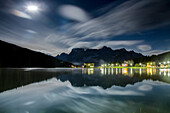 Clouds illuminated by the moon are reflected in Lake Misurina, Cortina d'Ampezzo, Dolomites, Veneto, Italy, Europe