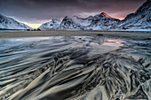 Waves on the surreal Skagsanden beach surrounded by snow covered mountains, Lofoten Islands Norway, Europe