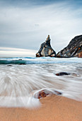 Ocean waves crashing on the sandy beach of Praia da Ursa surrounded by cliffs Cabo da Roca Colares Sintra Portugal Europe