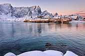 The colors of dawn frames the fishermen houses surrounded by snowy peaks Sakris+©y Reine Nordland Lofoten Islands Norway Europe