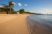 Blue sky and palm trees frame the beach and the Caribbean sea Hawksbill Bay Antigua and Barbuda Leeward Islands West Indies