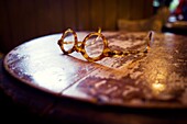 Gafas de concha sobre una mesa de madera vintage. Arncliffe, Skipton, North Yorkshire, Yorkshire Dales, UK.