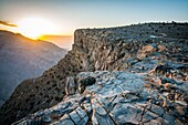 Jebel Shams, Sun shines over the summit and gorge at Oman's Grand Canyon.