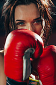Close-up young female boxer at gym