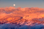 Valli di Sant'Antonio, LOmbardy, Italy, The full moon rise from Adamello group at sunset with clouds