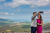 Connor pass, Dingle peninsula, County Kerry, Munster province, Ireland, Europe, Couple talking pictures with the smartphone
