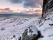 The fishing village surrounded by snow and cold sea under a colorful sky Eggum Vestvag?y Island Lofoten Islands Norway Europe