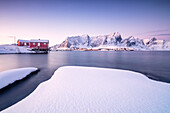 The colors of dawn frames the fishermen houses surrounded by frozen sea Sakris?y Reine Nordland Lofoten Islands Norway Europe