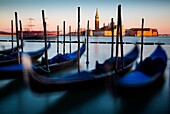 Venice, Veneto, Italy, View of San Giorgio cathedral during a quiet winter sunset, with gondolas on the foreground