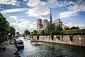 Notre Dame cathedral with puffy clouds, Paris, France.