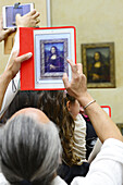Visitor taking a picture of the Mona Lisa, The Louvre Museum, Paris, France
