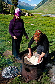 Kyrgyzstan, Issyk Kul Province (Ysyk-Kol), Juuku valley, Nurgul covers the oven with the famous kyrgyz koumkurme bread