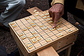Japan, Man playing micro shogi an old form of japanese chess