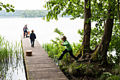 nature camping at Ellbogensee, lake, kids playing at a landing stage, Strasen, Mecklenburg lakes, Mecklenburg lake district, Mecklenburg-West Pomerania, Germany, Europe