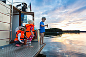 Children fishing on a boat, sunset, houseboat tour, lake Zotzensee, near lake Müritz, Kuhnle-Tours, Mecklenburg lakes, Mecklenburg lake district, MR, Mecklenburg-West Pomerania, Germany, Europe