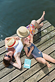 Mother and daughter lying on swimming platform, reading, sunbathing,  straw hat, swimming in a lake, beach, playing in the water, lake Granzower Möschen, holiday, summer, Mecklenburg lakes, Mecklenburg lake district, MR, Granzow, Mecklenburg-West Pomerani
