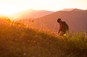 Junge Frau wandert auf den Muttlerkopf in den Alpen bei Sonnenaufgang
