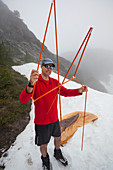A Confused Climber Holds Up His Tent Poles