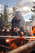 Close-up Of A Woman Cooks A Spiderdog Over A Fire