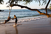 Children Playing With Rope Swing On Waialea Beach