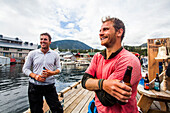 Team Members Enjoying Beer On Dock During The Race To Alaska