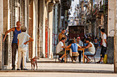 Havana, Cuba - Neighbors mill around a domino game in an Old Havana street scene