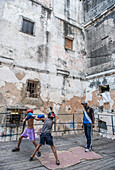 Two boys sparring on the makeshift ring at Project Cuba Boxeo, an aid project from Malaika Aid for Children, the creation of Samuel 'Sammy' Fabbri, who is seen coaching in this photo. The organization brings boxing to Cuban children from 8-21 years of age