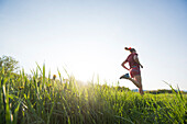 Woman Running On Grassy Field