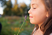 A Young Girl Smells A Stem Of Lavender