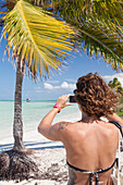 Tourist Girl Taking Picture With Her Smartphone On Beach Of Cuba