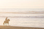 Gaucho/cowboy rides along Pacific surf edge