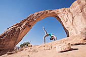A Fit Young Woman Practices Yoga Under Corona Arch, Moab, Utah
