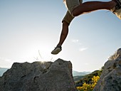 Man leaps onto rock above sea