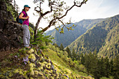 A Woman Standing On A Rock Exploring Lush Green Valley