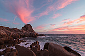 Rosa Himmel bei Sonnenuntergang auf den Wellen Absturz auf Klippen Capo Testa Santa Teresa di Gallura Provinz Sassari Sardinien Italien Europa