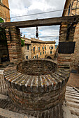The ancient stone well among the houses of the old town of Corinaldo Province of Ancona Marche Italy Europe