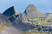 Rocky peaks frame the village of Sorland surrounded by sea Vaeroy Island Nordland county Lofoten archipelago Norway Europe