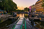 The Netherlands, Europe, sailing boat in Amsterdam canal at sunset