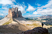 Europe, Italy, Dolomites, Veneto, Belluno, Woman hiker admire Tre Cime di Lavaredo from Trenches of the First World War on Mount Paterno