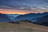 Winter Sonnenuntergang an den Hütten von Monte Alino über die Stadt Parre, Val Seriana, Bergamo Provinz, Lombardei, Italien