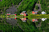 Perfekte Reflexion einiger typischer norvegia Häuser in einen See im späten Frühling, Odda, Hardaland, Norwegen