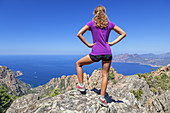 Woman on a trail in the Calanche enjoys the view over the Golf of Porto, between Porto and Piana, West Corsica, Corsica, Southern France, France, Southern Europe, Europe