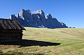 Small wooden hay cabin in front of the Geisler peaks, Dolomites, South Tirol, Italy