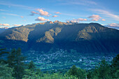 Draufsicht auf das Dorf Bianzone umrahmt von den felsigen Gipfeln der Rhätischen Alpen im Morgengrauen, Valtellina, Lombardei, Italien, Europa