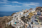Tageszeitansicht über die weißgetünchten Gebäude und Windmühle von Oia von den Burgmauern, Santorini, Kykladen, griechische Inseln, Griechenland, Europa