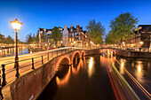 Dämmerung an typischen Gebäuden und Brücken, die sich in einem typischen Kanal, Amsterdam, Holland (Niederlande), Europa, widerspiegeln