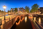 Dusk lights on typical buildings and bridges reflected in a typical canal, Amsterdam, Holland (The Netherlands), Europe