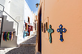Souvenirkreuze auf der Außenseite eines Geschäftes auf einer Straße in Oia, Santorini, Kykladen, griechische Inseln, Griechenland, Europa