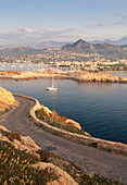 Ein Segelboot im klaren Meer um das Dorf Ile Rousse bei Sonnenuntergang, Balagne Region, Korsika, Frankreich, Mittelmeer, Europa