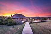 Hlosi Game Lodge bei einem spektakulären Sonnenuntergang über dem Amakhala Game Reserve auf dem Eastern Cape, Südafrika, Afrika